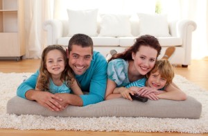 Smiling family on floor in living-room